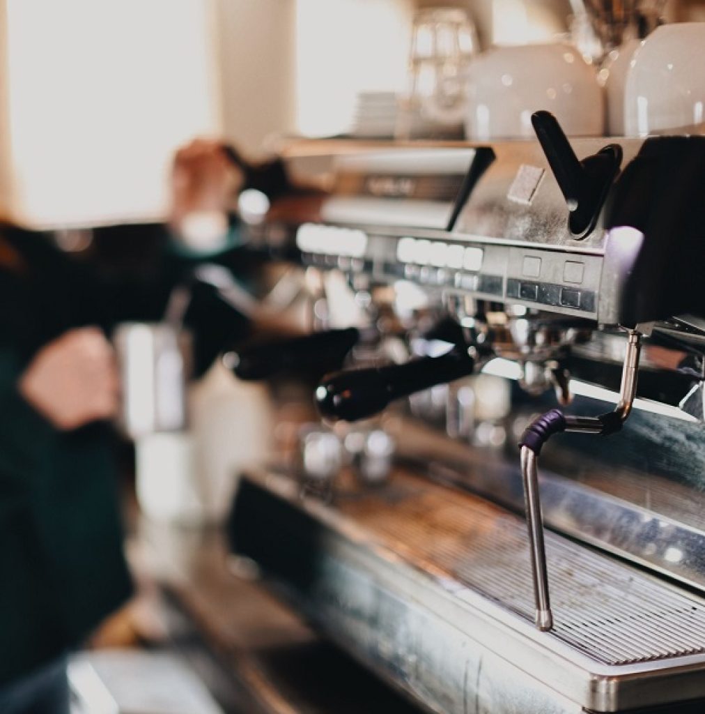 A barista serves coffee at a coffee shop business