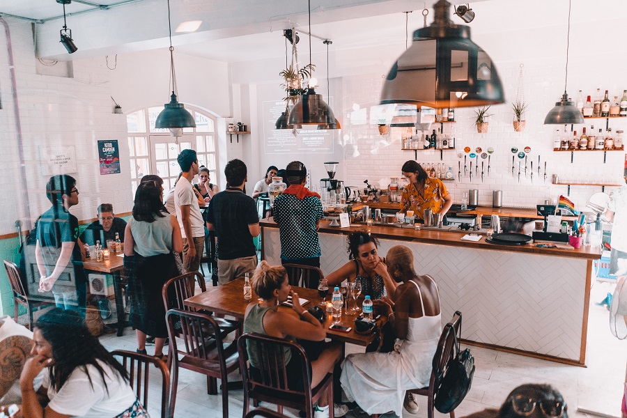 A busy coffee shop scene with customers drinking coffee and alcohol
