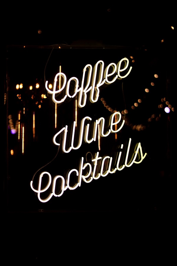 A coffee shop sign says coffee, wine, and cocktails