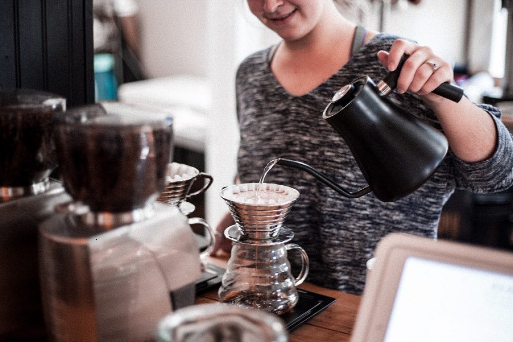 home-based coffee shop business. A Barista pours coffee in her home.