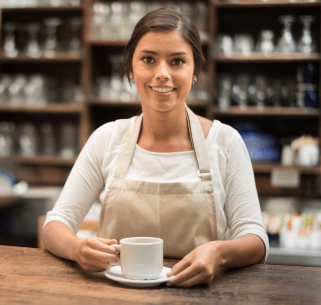 a barista serves a coffee at her coffee shop. 