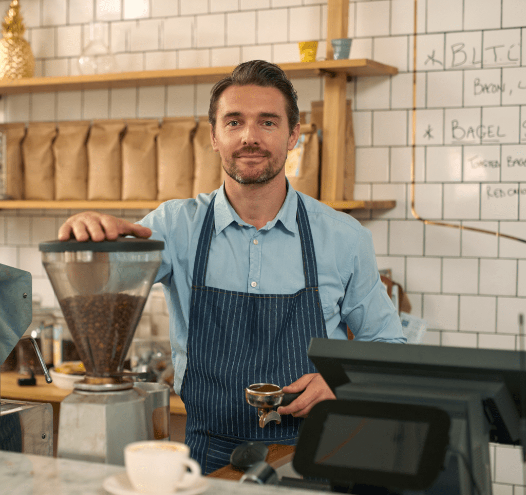 A coffee shop owner holds a portafilter