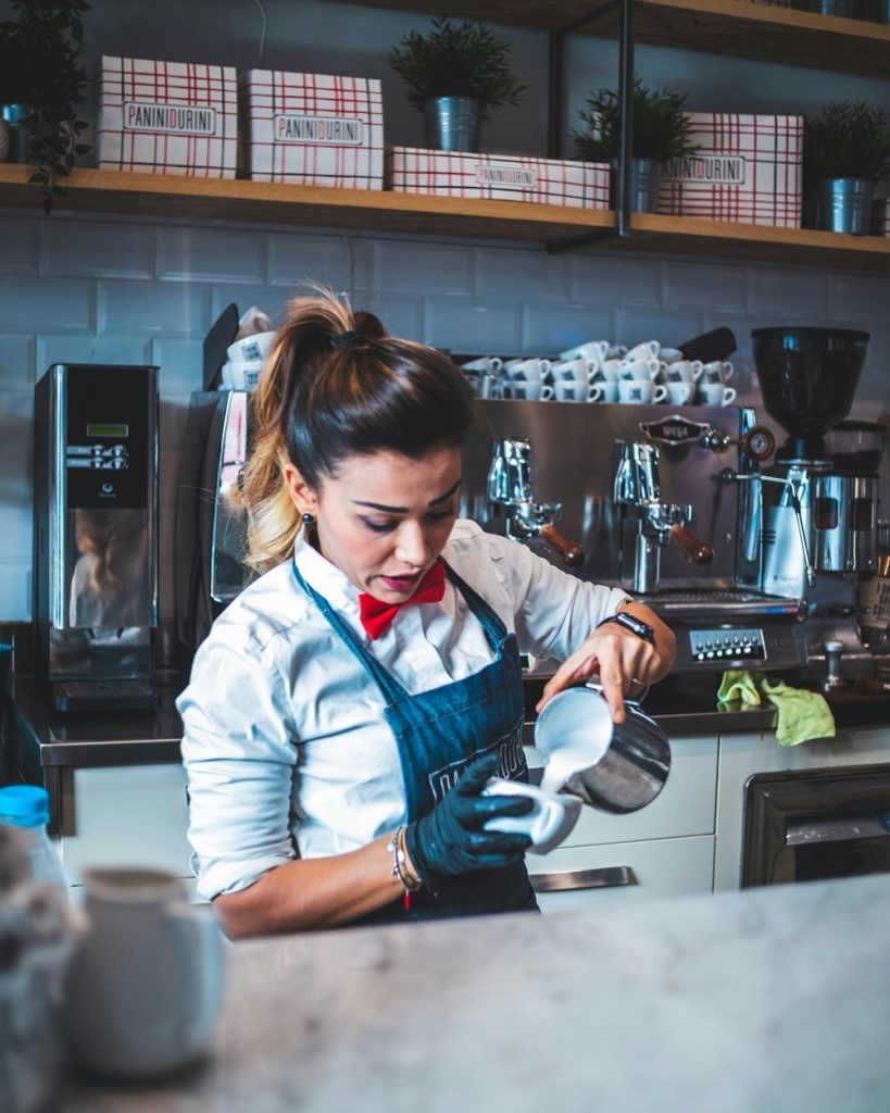 start a coffee shop business. Here a barista pours a coffee.